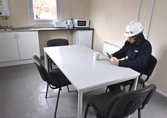 employee sat at table in modular welfare unit